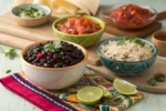 Bowl of freshly cooked black beans with rice, lime, and salsa.